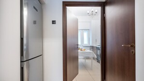 Una cocina moderna con una mesa de comedor, un refrigerador y una lámpara de araña.