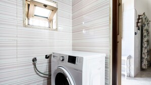 A compact laundry room with a front-loading washing machine, a small window, and a door leading to another room. - 4196 Tina House & Parking by Barbarhouse (Bari)