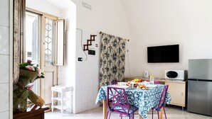 A kitchen with a dining table, chairs, a TV, and a refrigerator. - 4196 Tina House & Parking by Barbarhouse (Bari)
