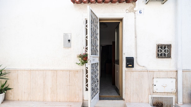 A white building with a tiled roof, a door with a decorative grille, a potted plant, and a small window with a metal grille. - 4196 Tina House & Parking by Barbarhouse (Bari)