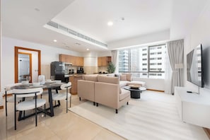 Een modern appartement met een eethoek, keuken, woonkamer en een groot raam met uitzicht op de stad.