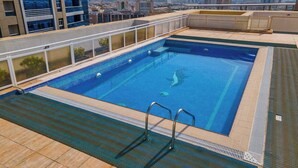 Une piscine sur le toit offrant une vue panoramique sur la ville.