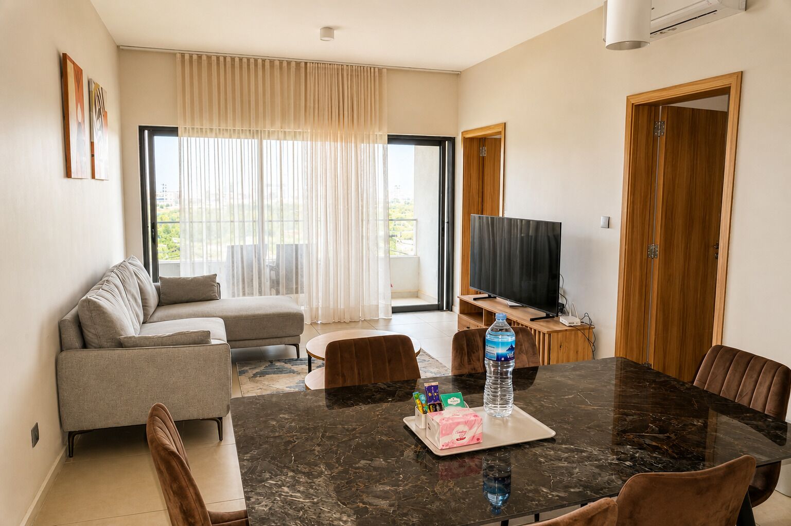 Una sala moderna con un sofá, una mesa de comedor y un televisor.