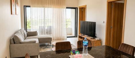 Una sala moderna con un sofá, una mesa de comedor y un televisor.