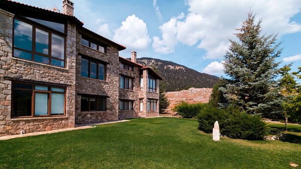 A stone building with multiple windows and a well-maintained lawn. - Arachova in Arachova (Distomo-Arachova-Antikyra)