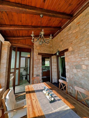 A rustic dining area with a wooden table, chairs, and a chandelier. - Arachova in Arachova (Distomo-Arachova-Antikyra)