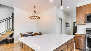 A modern kitchen with a large island, wooden cabinets, and stainless steel appliances. - Mtn-view 'slopeside Chalet' in Granby Ranch! (Granby)