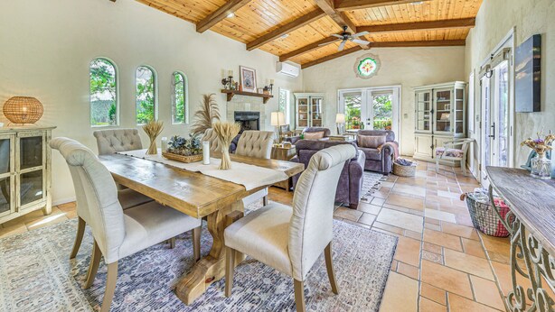 A spacious living area with a wooden ceiling, a dining table with chairs, and a fireplace. - Ruidoso Retreat w/ Hot Tub & Patio! (Ruidoso)