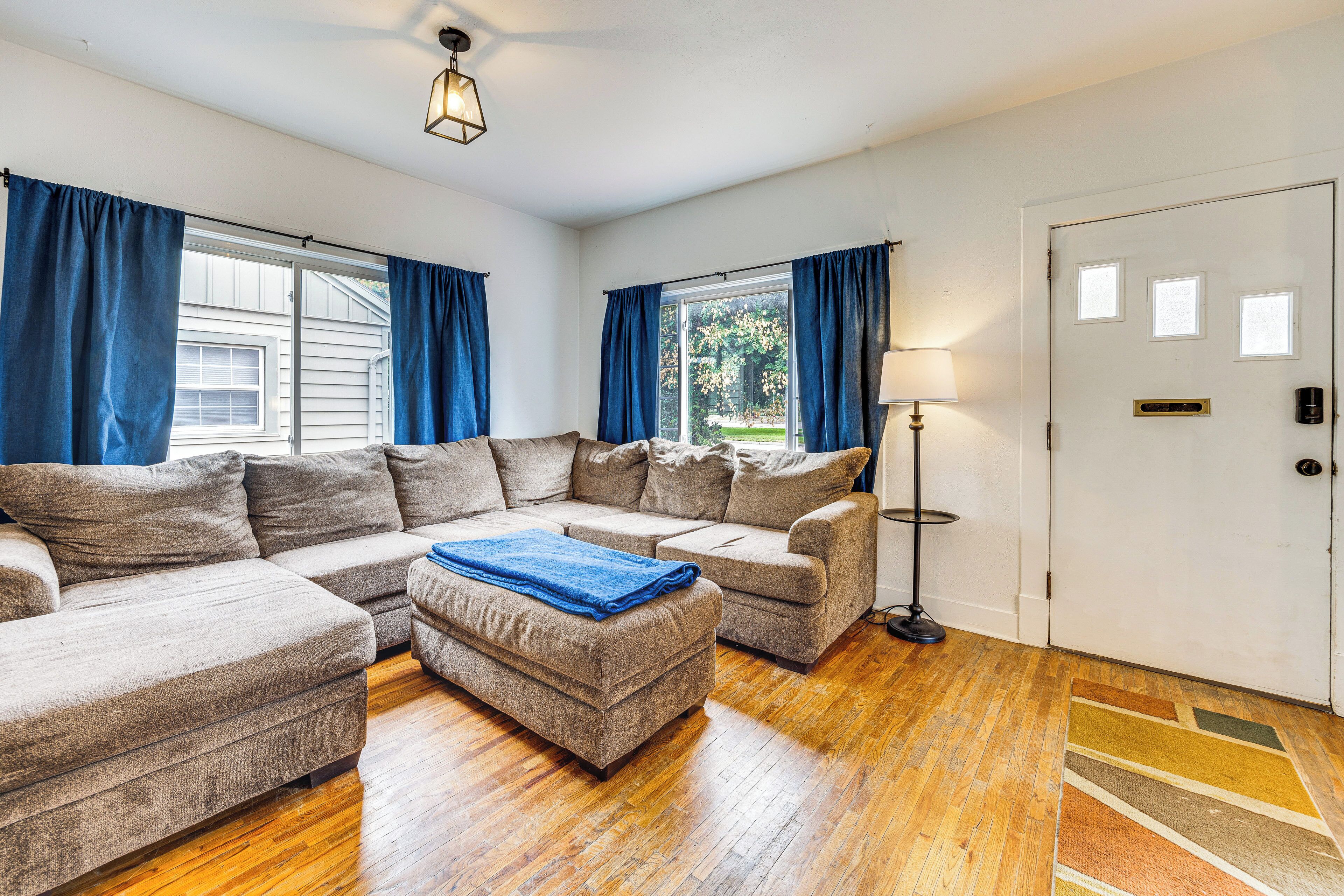 A living room with a sectional sofa, a floor lamp, and a door with a window.