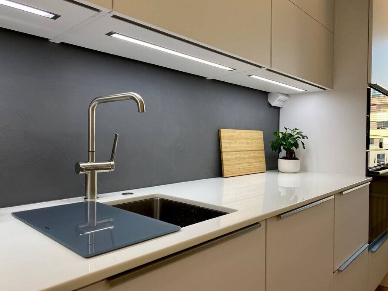 A modern kitchen with a sleek faucet, a built-in sink, and a wooden panel backsplash.