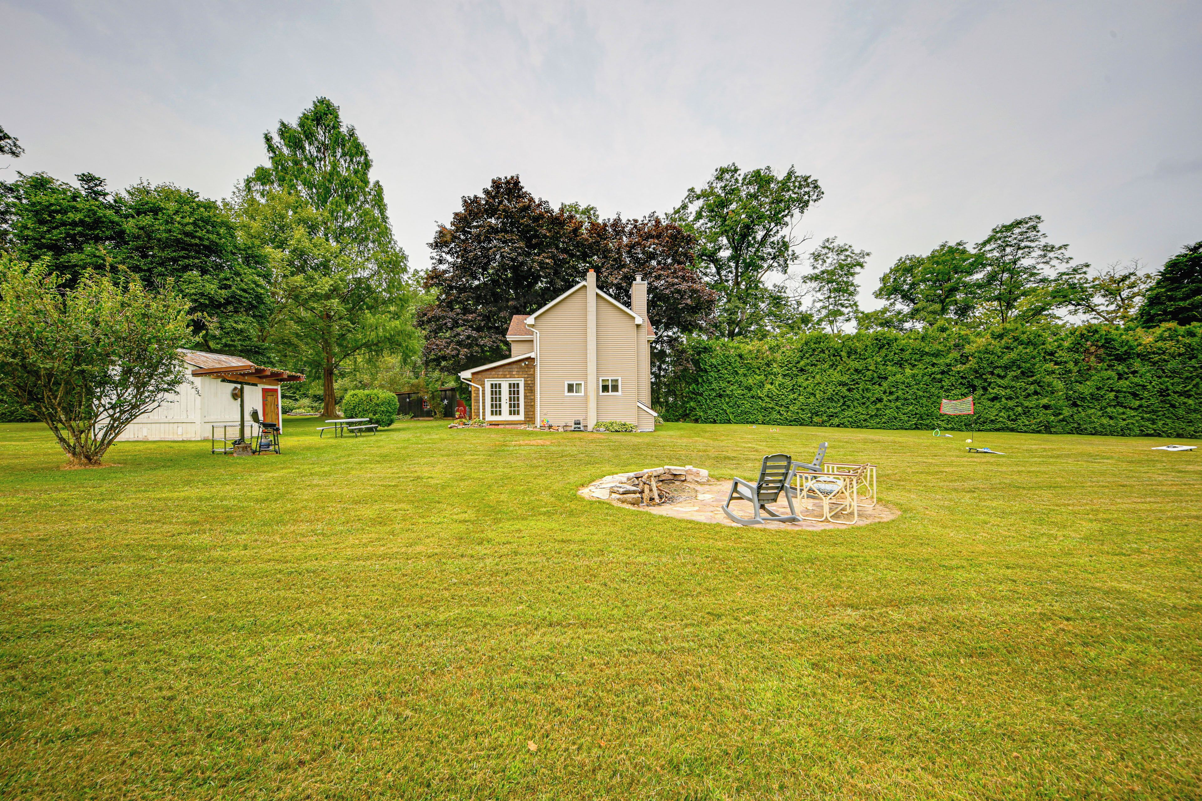 A house with a backyard featuring a fire pit and outdoor seating.