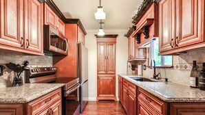 A kitchen with wooden cabinets, granite countertops, stainless steel appliances, and a central island. - Home w/ Decks & River Access in Mt Gilead! (Mount Gilead)