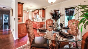 A dining area with a glass table, wooden chairs, and a chandelier. - Home w/ Decks & River Access in Mt Gilead! (Mount Gilead)