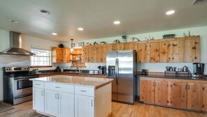 A spacious kitchen with wooden cabinets, stainless steel appliances, and a large island. - Texas Nature Escape: Lake & Game Room Access (D'Hanis)