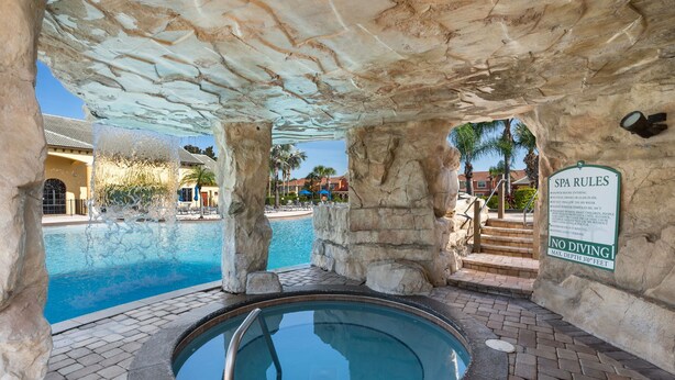 Zona de spa con jacuzzi, piscina y un cartel que indica 'SPA RULES' y 'NO DIVING'.