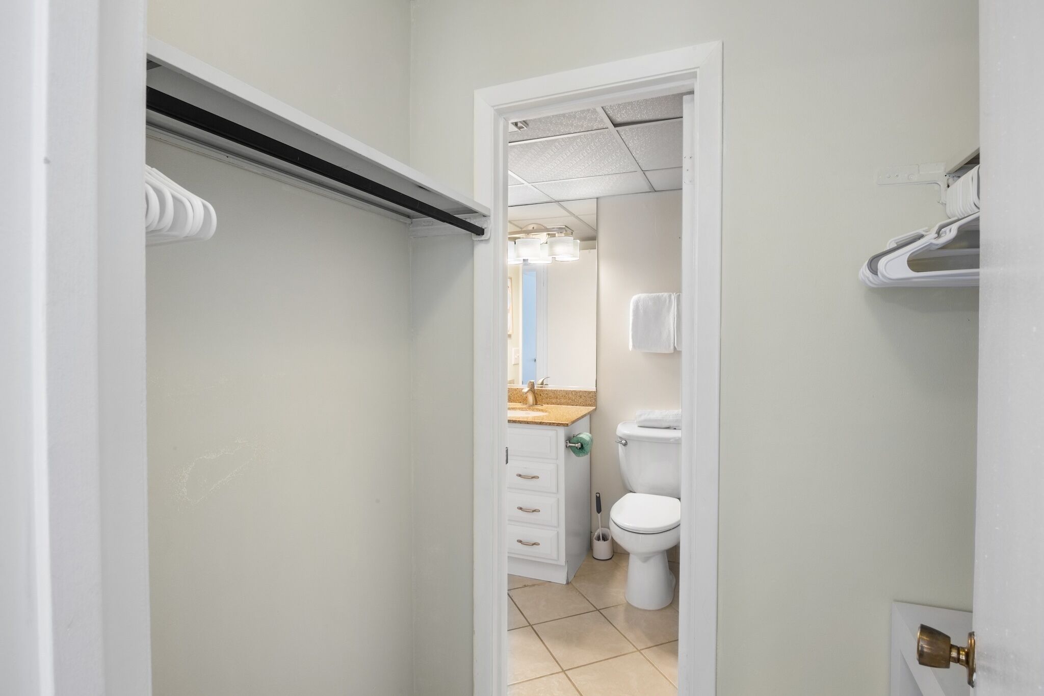 A bathroom with a toilet, sink, and mirror.