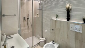 A modern bathroom with a glass-enclosed shower, a bidet, a toilet, and a sink with a faucet. - Delightful apartment with modern and comfortable style near the beach (Marina di Andora)