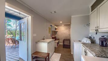 A compact kitchen with a sink, a washing machine, and a countertop.