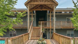 A two-story wooden building with a central staircase and a balcony on the upper level. - Lakefront Lodge by Innsbrook Vacations! (Innsbrook)