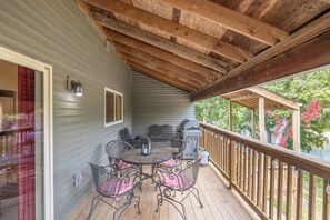 A covered outdoor area with a wooden deck, metal grill, and a table with chairs. - Lakefront Lodge by Innsbrook Vacations! (Innsbrook)