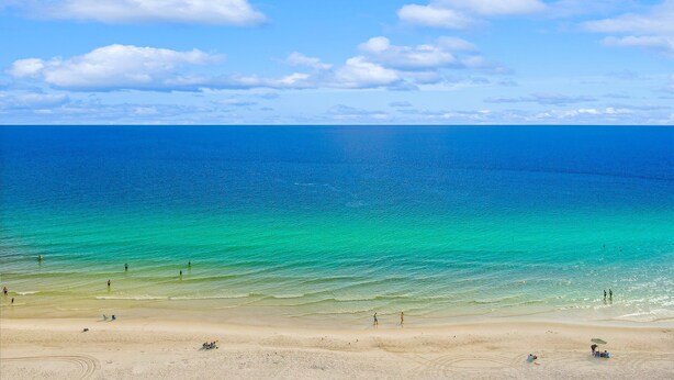 Una playa con aguas turquesas transparentes y una orilla arenosa.