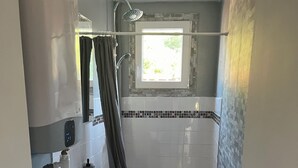 A compact bathroom with a toilet, sink, and shower.