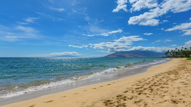 A beach with clear blue water, a sandy shore, and a mountain in the background. - Partial OV w/WiFi, A/C, Connecting Rooms-G510AB (Kihei)