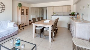 Un salon moderne comprenant un canapé, une table à manger, des chaises et une table basse.