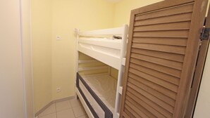 A bunk bed in a room with yellow walls and a wooden door. - 1 bedroom accommodation in Nieuwpoort (Nieuwpoort)
