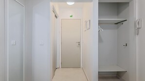 A hallway with a welcome mat, a door, and a closet with hanging clothes. - 2 bedroom accommodation in Oostduinkerke (Oostduinkerke)