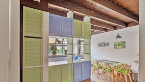 A dining area with a table and chairs, a window with shutters, and a ceiling with exposed beams. - 2 bedroom accommodation in Nieuwpoort (Nieuwpoort)