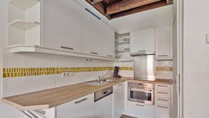 A modern kitchen with white cabinets, a wooden countertop, and a tiled backsplash. - 2 bedroom accommodation in Nieuwpoort (Nieuwpoort)