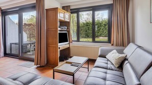 A modern living room with a sofa, a coffee table, and a TV stand. - 3 bedroom accommodation in Nieuwpoort (Nieuwpoort)