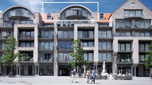 A multi-story building with balconies, a central courtyard, and a clear sky.
