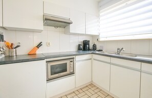 Een koelkast, een oven, een kookplaat, een koffiezetapparaat/waterkoker