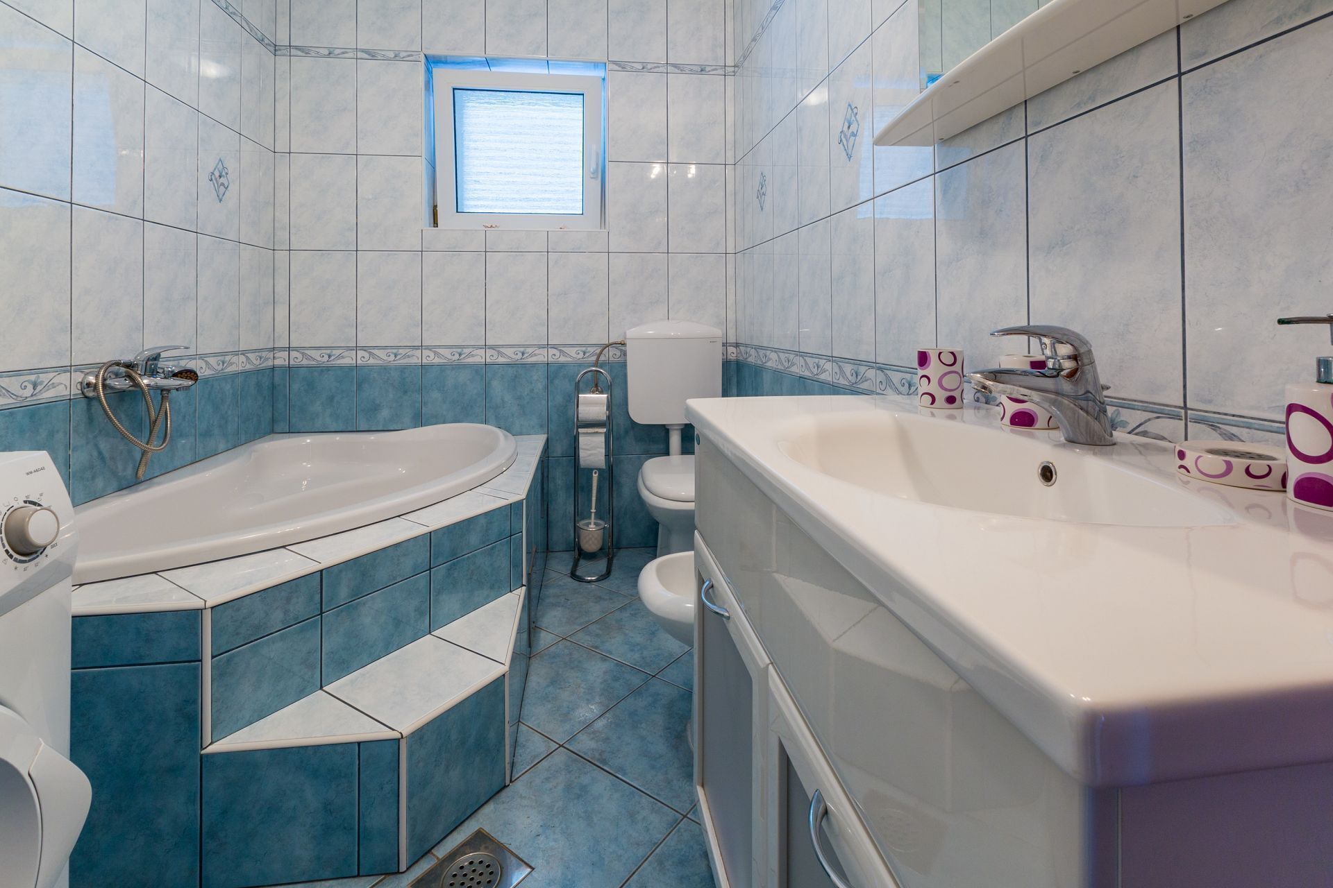 Un baño con una bañera, un lavamanos grande y un inodoro.