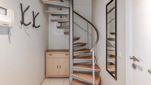 A modern interior with a spiral staircase, a wooden cabinet, and a coat hook. - 2 bedroom accommodation in Oostduinkerke (Oostduinkerke)