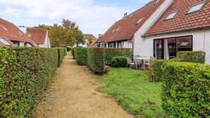 A row of houses with sloped roofs and a gravel path between them.