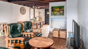 A cozy living room with a leather sofa, wooden coffee table, and a television.