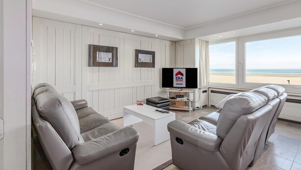 A modern living room with a sofa set, a TV, and a view of the beach. - 3 bedroom accommodation in Oostduinkerke (Oostduinkerke)