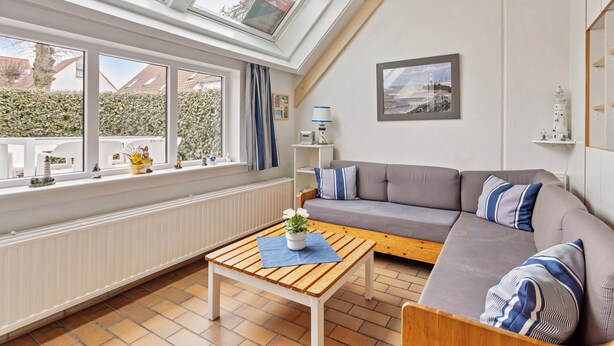 Ein modernes Wohnzimmer mit einer Couch, einem Holztisch und einem Oberlicht.