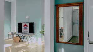 Una sala de estar moderna con una televisión, una mesita y una planta.