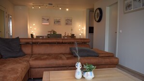 Un salon avec un canapé marron, une table basse et des vases décoratifs.