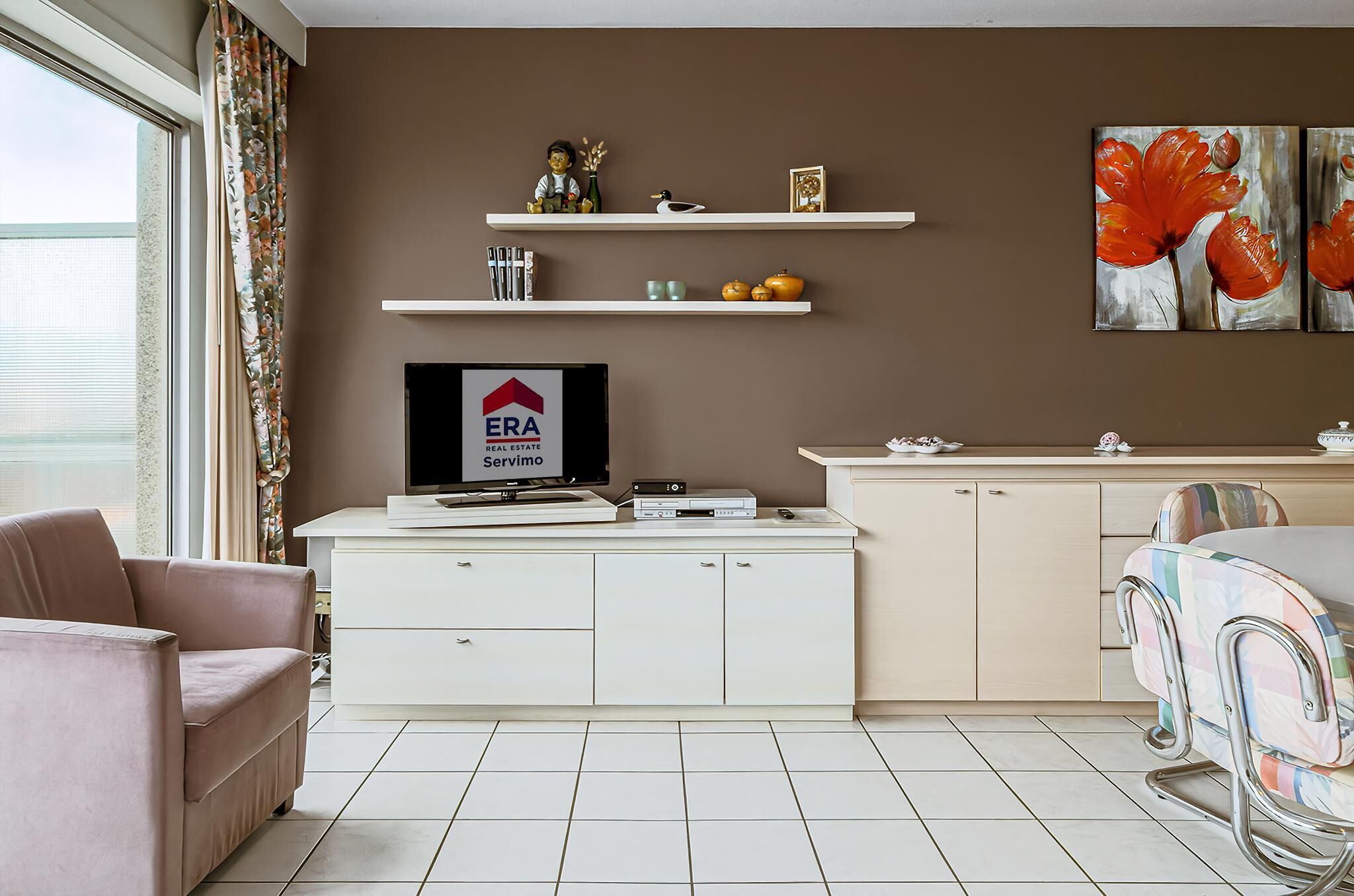 Ein modernes Wohnzimmer mit einer Couch, einem Esstisch mit Stühlen, einem Fernseher auf einem Schrank und Kunstwerken an der Wand.