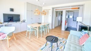 En modern lägenhet med matplats, kök och vardagsrum.