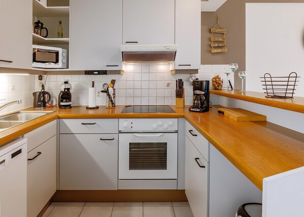 Een koelkast, een oven, een kookplaat, een koffiezetapparaat/waterkoker
