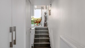 A narrow hallway with a staircase leading to a balcony. - 2 bedroom accommodation in Oostduinkerke (Oostduinkerke)