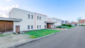 A modern two-story residential building with a flat roof, large windows, and a well-maintained lawn. - 2 bedroom accommodation in Oostduinkerke (Oostduinkerke)
