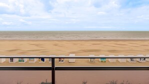 A beach view with a railing and lounge chairs. - 4 bedroom accommodation in Sint Idesbald (Sint Idesbald)