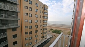 A high-rise building with multiple balconies overlooking a beach. - WESTDIEP DOM.0502+G1074 (Nieuwpoort)
